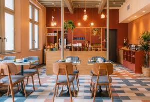 a restaurant with tables and chairs and a kitchen at La Maison Rabelais in Amboise
