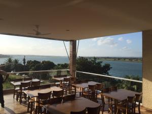 a balcony with tables and chairs and a view of the water at Pousada e Restaurante Manah in Propriá