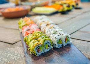a row of sushi sitting on top of a wooden table at Spirit Hotel Benalmadena Beach in Benalmádena