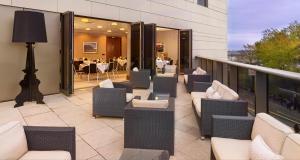 a balcony with chairs and tables on a building at Clayton Hotel Birmingham in Birmingham