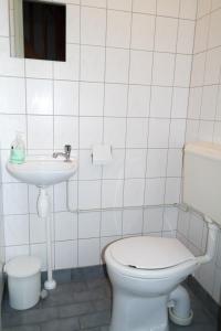 une salle de bains blanche avec toilettes et lavabo dans l'établissement Dike House Affordable 6-Person Holiday Home Near the Sea Dike, à Anjum 30 autres photos