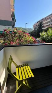 a yellow bench sitting on top of a balcony at Rapallo-Portofino, Elegant & Comfortable House in Rapallo