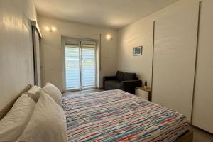 a bedroom with a bed and a chair and a window at Rapallo-Portofino, Elegant & Comfortable House in Rapallo