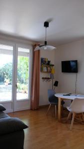 a living room with a table and a window at Appartement de plein pied Toulouse Nord in Castelginest