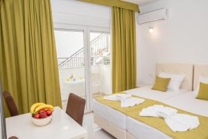 a bedroom with two beds and a table with a bowl of fruit at Apartmani Nela Sutomore in Sutomore