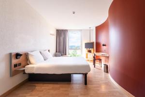 een hotelkamer met een bed en een raam bij B&B HOTEL Lully 3 Lakes in Estavayer-le-Lac