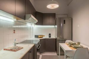 a kitchen with a stainless steel refrigerator and a table at Empyrean Apartment in Athens