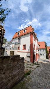 een wit en oranje gebouw met een hek ernaast bij Altes Zollhaus - Central - Lovely - Luxury - Maisonette Apartment in Schwabach