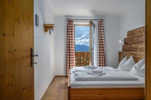 a bedroom with a large bed with a window at Das Eulersberg Apartments & Chalets in Werfenweng