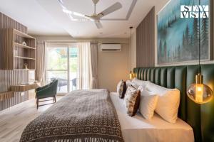 una camera da letto con un letto grande con testiera verde di StayVista at The Sweet Sunsation with Jacuzzi, BBQ a Gurgaon Altre 28 foto