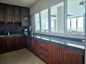 una cucina con armadi in legno e una grande finestra di Phuket Great Property a Phuket