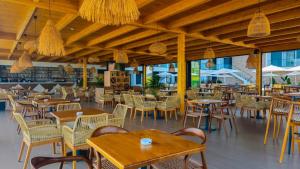 an empty restaurant with tables and chairs and windows at Black Diamond Hotel Dhermi in Dhërmi