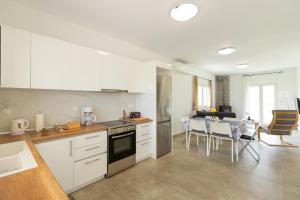 a kitchen with white cabinets and a table and a dining room at Countryside apartments ground floor in Gómfoi