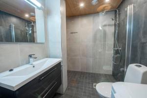 a bathroom with a sink and a shower and a toilet at Pärjä Suites 3 in Syöte +6 photos