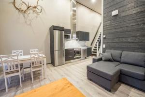 a kitchen and living room with a couch and a table at Pärjä Suites 3 in Syöte