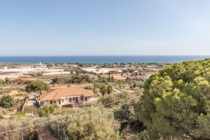 a house on a hill with the ocean in the background at Casa Andrea in Marina di Ragusa