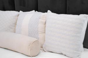a group of pillows sitting on top of a bed at The Base Apartment in Johannesburg +9 photos