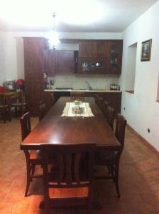 a kitchen with a wooden table and chairs in a room at B&b La Casa Del Sole in Borgaria