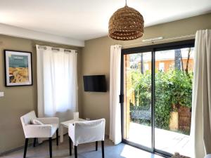 a living room with a table and chairs and a sliding glass door at Côté plage in Lacanau-Océan
