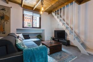 Una sala de estar con un sofá y un televisor. en Los Corceles Casa Palacio, en Jerez de la Frontera