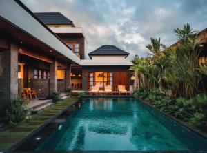 a house with a swimming pool in front of a house at Kubera Villa Kemenuh by Prasi in Ubud