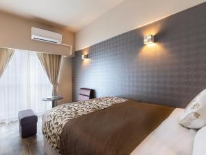 a hotel room with a bed and a window at CONDOMINIUM HOTEL Riyuka in KADENA 1 in Kadena