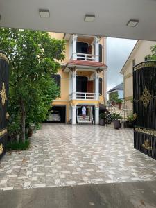 a house with a gate and a stone driveway at Nhà Nghỉ Long Lưu in Vinh