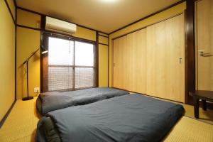 Postel nebo postele na pokoji v ubytování Guest House 伏見稲荷