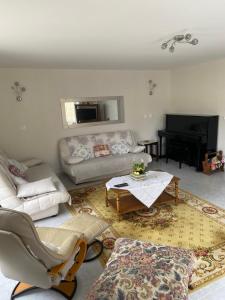 un soggiorno con un divano e un tavolo di La Maison d'Aimé - Spacieuse et grand jardin a Banville