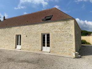 un edificio in mattoni con finestra e tetto di La Maison d'Aimé - Spacieuse et grand jardin a Banville