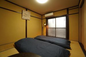 Postel nebo postele na pokoji v ubytování Guest House 伏見稲荷