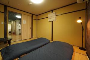 Postel nebo postele na pokoji v ubytování Guest House 伏見稲荷