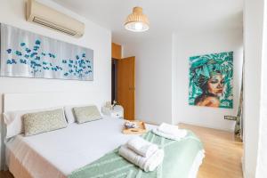 a white bedroom with a bed and a painting on the wall at Grand Villa Valencia- large groups-8 min to Center by Metro in Valencia +199 photos