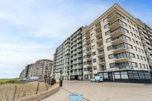 un grand bâtiment avec un parking devant dans l'établissement Seanita - sea view apartment in Westende, à Middelkerke