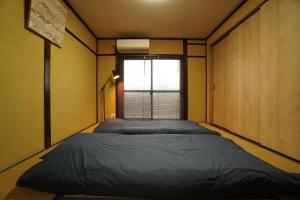 Postel nebo postele na pokoji v ubytování Guest House 伏見稲荷