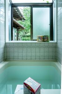 e bagno con finestra e vasca. di 一宿一景一生縁-千葉県市原市小谷田店 a Ichihara