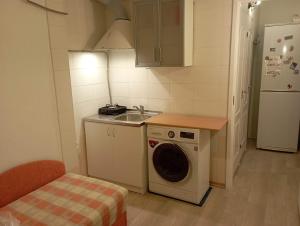 a small kitchen with a washing machine and a sink at A comfortable room with balcony in Tallinn