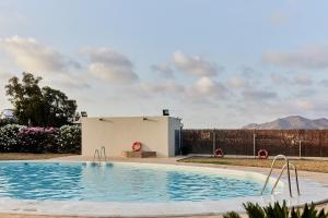 a swimming pool in front of a house at TAIGA Almeria Playa in Palomares