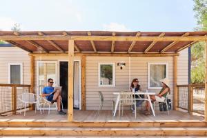 a group of people sitting on a deck with a pergola at TAIGA Almeria Playa in Palomares +37 photos