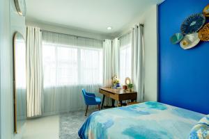 a blue bedroom with a desk and a blue wall at Cozy Modern 2BR Loft, Monterrazas, Cebu City in Baksan