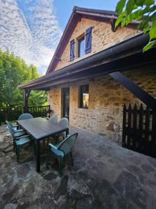 a patio with a table and chairs and a building at Charmante Maisonette du Lot rénovée avec balnéo in Latouille-Lentillac