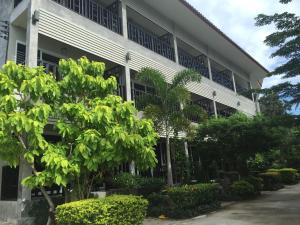 a white building with trees in front of it at Baan Suan Ta Hotel in Koh Tao