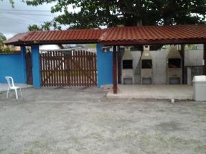 a blue and white building with a pavilion with a chair at Hotel Pousada Praia e Sol in Bertioga