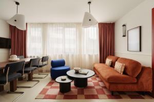 un soggiorno con un divano, un tavolo e delle sedie di Edgar Suites Montrouge a Montrouge Altre 39 foto