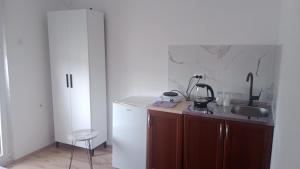 a kitchen with a sink and a white refrigerator at Studio Dream I I in Šušanj