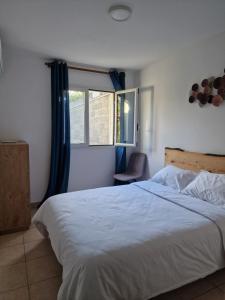 a bedroom with a bed and a chair and a window at La villa'mie in Saint-André