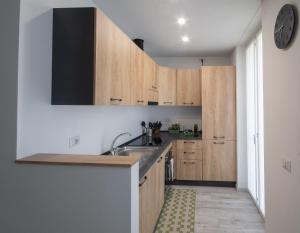a kitchen with wooden cabinets and a sink at Casa Vacanze SweetLand Chiavenna in Chiavenna