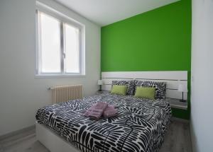 a bedroom with a zebra bed with a green wall at Casa Vacanze SweetLand Chiavenna in Chiavenna