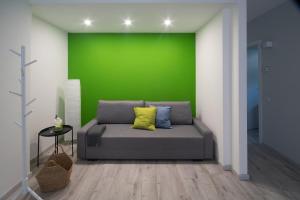 a room with a bed with a green wall at Casa Vacanze SweetLand Chiavenna in Chiavenna