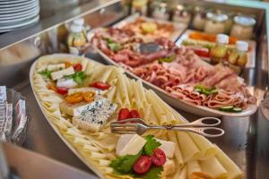 a buffet of different types of food on a table at Platzhirsch Rooms - B&B - SELF CHECK-IN in Piesendorf